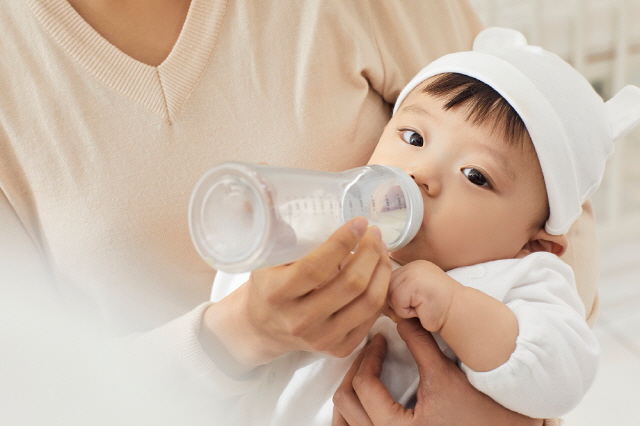 모자가 아기에게 젖병을 물리는 장면, 유당불내증 가능성이 있는 영아의 수유 모습